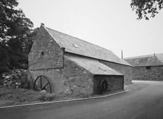 Exterior view of mill from SW, showing gable with undershot (start & awe) water-wheel and concrete lade