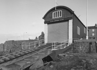 View from South-East of lifeboat station, including boat house and slipway.