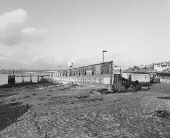 General view from S looking down the ramp towards the Tay.  The Tay Road Bridge, which replaced the ferry service in 1966, can be seen in the background