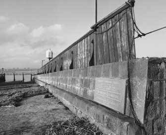 View of central wall (including commemorative plaque) from S, looking down the ramp towards the Tay