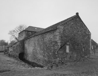 View form S of SW side of mill range, showing the tailrace emerging from the water-wheel house