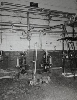 Interior view of boiler houseshowing small pumps and some of the pipework.