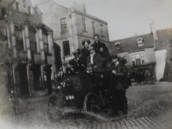View of group of people in motorcar, Duns. The same group appear in photographs of Dr Welsh's House, Haddington.