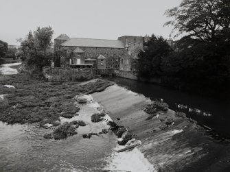 General view of Gimmers Mill from SSW, with weir in foreground.