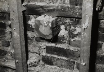 Interior.
Detail of first floor S wall showing sawn off beam end.
