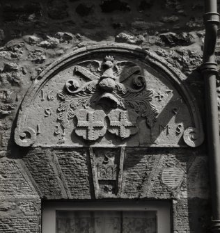 Detail of carved-stone semi-circular heraldic panel of Sinclair Family (possibly relocated from Herdmanston House when it was demolished in 1970s) in the SW wall of the Stables House (former Coach House) bearing the date 1647, with dated voussoir (1805) beneath.