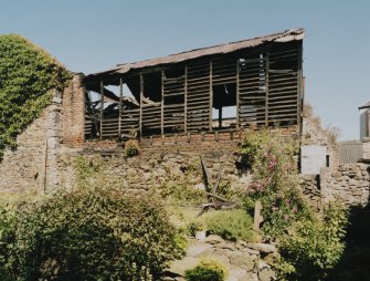 View of two storey wooden shed (to rear) from W.