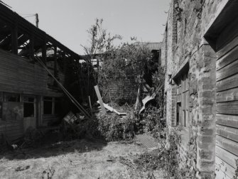 View of two storey wooden shed (to rear) from S.