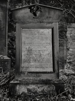 View of gravestone against S wall of church.