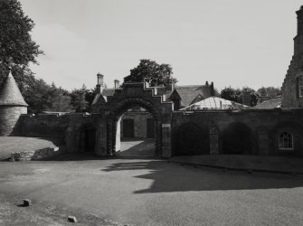 View of arched entrance to stable block from N.