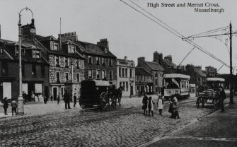 View from south west showing High Street and Market Cross (postcard).
Insc: 'High Street and Mercat Cross, Musselburgh', '47051, J V'.
NMRS Survey of Private Collections.