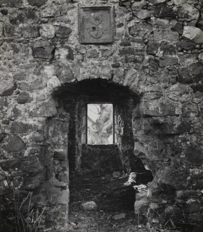 Detail showing entrance doorway and armorial panel on N wall.