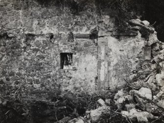 Interior.
View of window and blocked doorway in re-entrant angle of N wall.