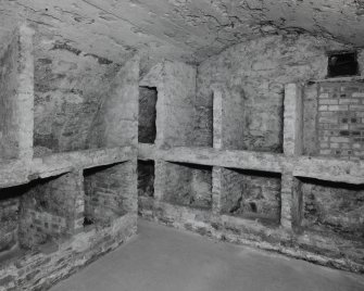 Interior. 
Ground floor vaulted wine cellar showing stone and brick wine bins.