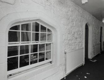 Interior. Ground floor entrance hall showing S wall of tower with arched openings
