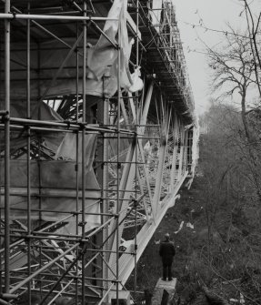 Oblique view from NNW of W side of bridge during re-furbishment, with human figure for scale.