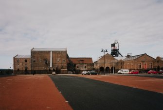 General view of S portion of colliery surface buildings from E following the demolition of the north end of the neighbouring workshops and the construction of a carpark for the museum.
