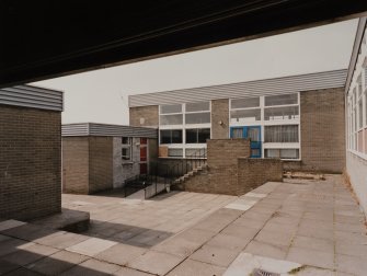 View from ENE of covered area to W of E wing communal area.