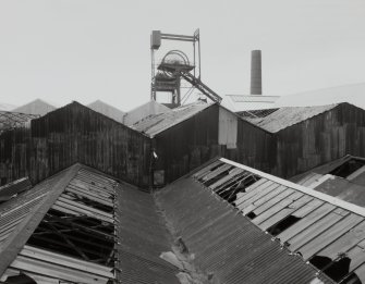 Newtongrange, Lady Victoria Colliery, Pithead Building (tub Circuit, Tippler Section, Picking Tables)
View from S of the colliery headgear, with the corrugated sheet-metal roofs and upper walls of the Picking Tables and Tub Circuit buildings in the foreground