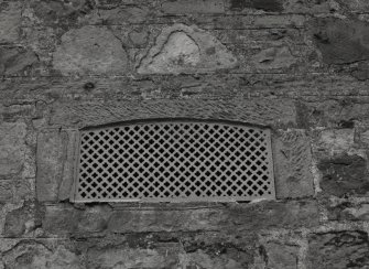 Detail of ornate cast-iron iron vent in wall at E corner of steading.