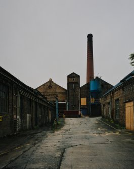 View from SSE showing paper mill (left), 'clay building (right), and boilerhouse and chimney (centre)