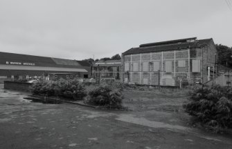 General view from N of main paper mill production block (left), and tall steel-framed brick building at NE end of complex (function not specified on site plan)