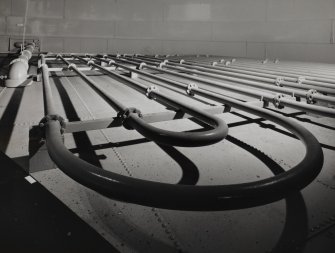 Circular oil-storage tank, interior.
Detail showing steam pipes on the floor