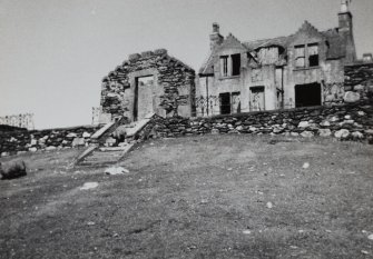 View of ruined entrance in wall and house from SW.