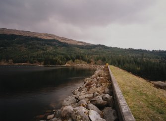 Dam (NM 97 42) supplying water to works: View of Dam from N, showing earth bank (right), and washed boulders (left) protecting the dam on the reservoir (E) side