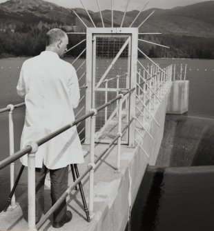 Dam (NM 97 42) supplying water to works: Detailed view of entrance to spillway from WNW, with Jim Mackie (RCAHMS Photographer) in foreground