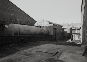 View from SW of fuel-oil tanks (for Maltings kiln, Wash Still and Boiler House), and Boiler House, with Duty Free Warehouse No. 5 (racked storage) in background (left)