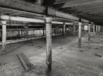Campbeltown, Millknowe Road, Hazelburn Distillery, interior.
View of First Floor central maltings block from South showing drop in floor level to neighbouring North-West maltings block and double cast iron columns between the blocks.
