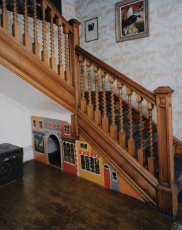 View of staircase from South showing understairs mural of shops.