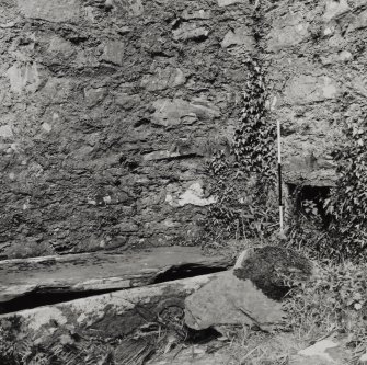 Walling of chapel and grave slab.