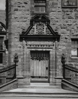 Detail.  SE entrance showing carved panels above door.