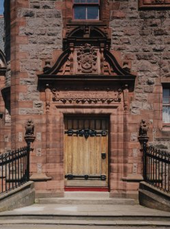 Detail.  SE entrance showing carved panels above door.