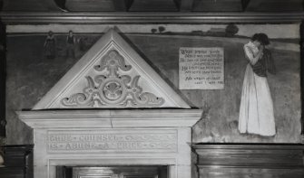 Interior.  Detail of mural and carving above library door in N corridor.