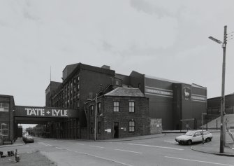 General view from NW of W end of S block of factory, showing (L to R) West Gangway over Drumfrochar Road (building no. 27, NS2783 7544), Granulating/Drying/Cooling (building no. 9, NS2787 7542), Sieving & Bag Filling (building no. 8, NS2784 7543), gatehouse (building no. 4, NS 2782 7544) and East Warehouse buildings (building no. 25, NS 2784 7540)