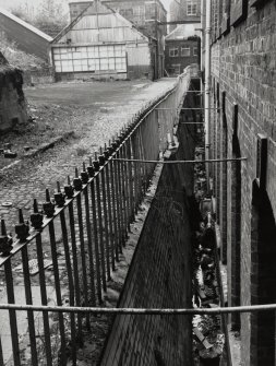 View of glazed enamel retaining wall of six-storey mill from E.