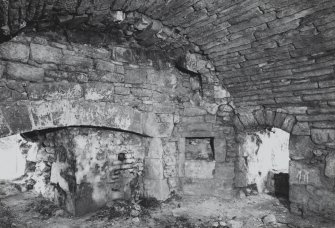 Interior.
View from SE of kitchen fireplace, W wall on ground floor