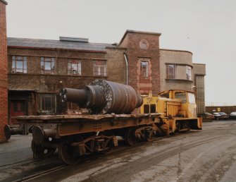 View from NE of N end of Offices, with GEC 'Stephenson' diesel pug locomotive and unfinished steel roll on wagon, awaiting delivery to Dressing Shop