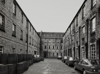 View from NE down yard enclosed by main multi-storeyed blocks of the works.  Photosurvey 23-APR-1992