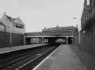 General view from S end of platform, showing bridge carrying Keptie Street over railway, with main station offices and booking hall just visible above parapet.