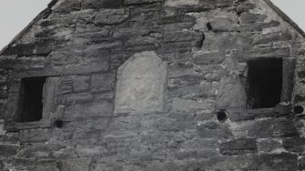 Detail of N gable showing windows and carved panel.