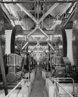 Drum Room:  view from E at lower level down centre of Drum Room between the two rows of 12 rim-gear-driven maltings drums, also showing Crofts (Engineers) of Bradford gear boxes.  The Drums were made by Robert Boby Ltd of Bury St Edmonds (a Vickers Ltd company)