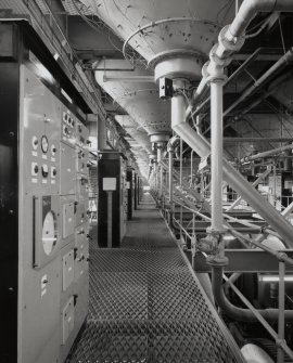 Drum Room:  interior view from E down S side of Drum Room, showing electrical control panels (left), conical bases of steeps (above), and rotating drums below