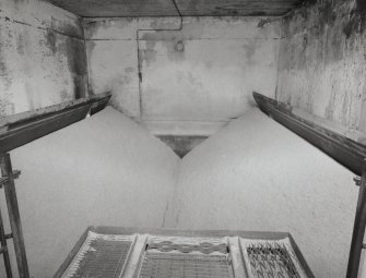 Kilns:  view from W looking into Kiln No.4, showing its wire-mesh floor in tilted position, allowing dried malt to fall into conveyors below