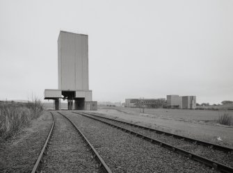 General exterior view from SW of maltings' rail siding and dispatch silo/hopper, with maltings in background