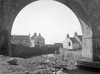 View from north looking through arch of railway viaduct towards harbour, Railway Inn and Crusoe Hotel