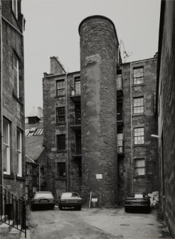 View from South showing rear of tenements and staircase tower.